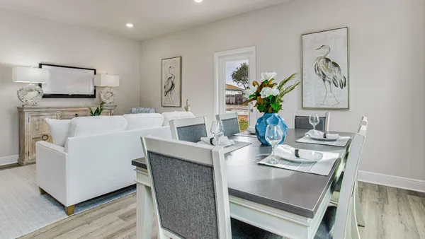 a living room with furniture a potted plant and a table