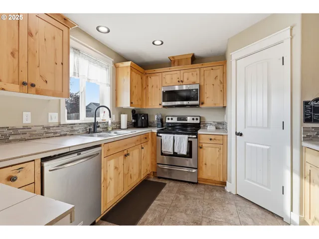 a kitchen with appliances a sink and cabinets