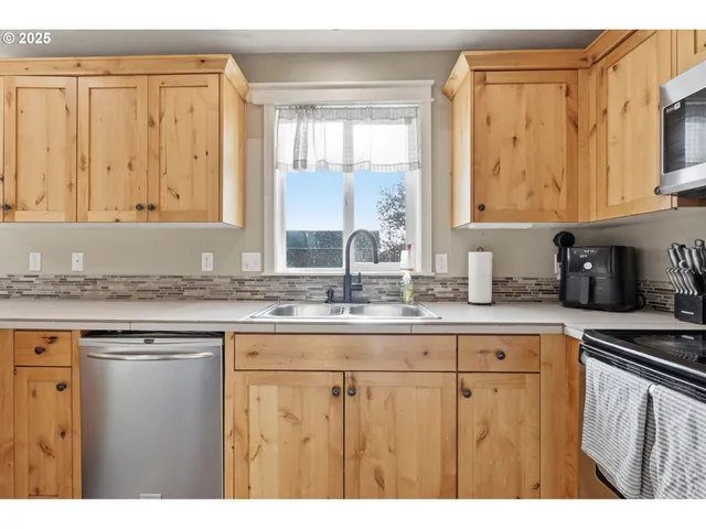 a kitchen with granite countertop a sink a window and cabinets