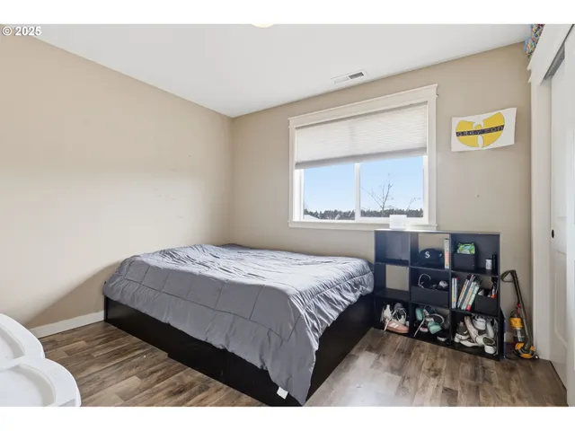 a bedroom with a bed a table and painting