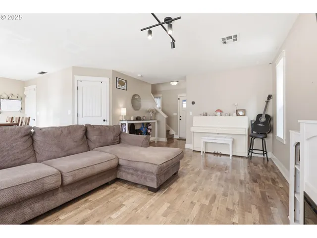 a living room with furniture and a wooden floor
