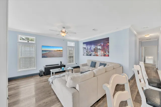 a living room with furniture a flat screen tv and a window