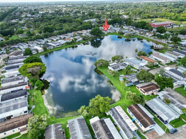 an aerial view of a house with yard swimming pool and lake view in back