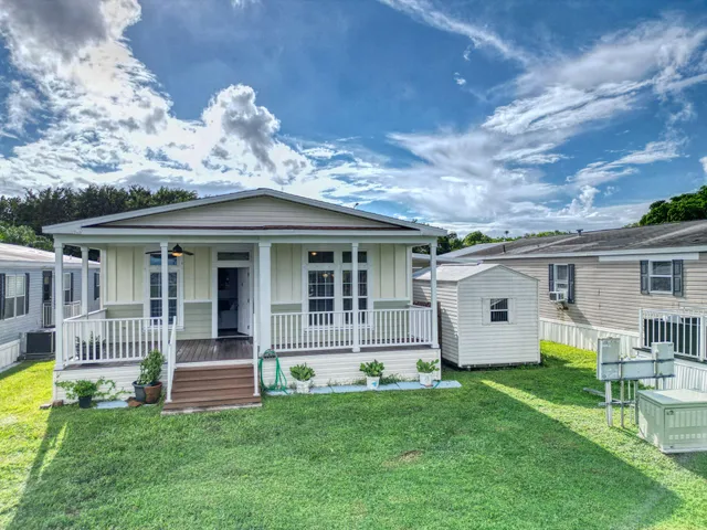 a front view of a house with a garden and yard