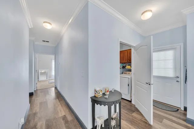 a view of a hallway with wooden floor and closet