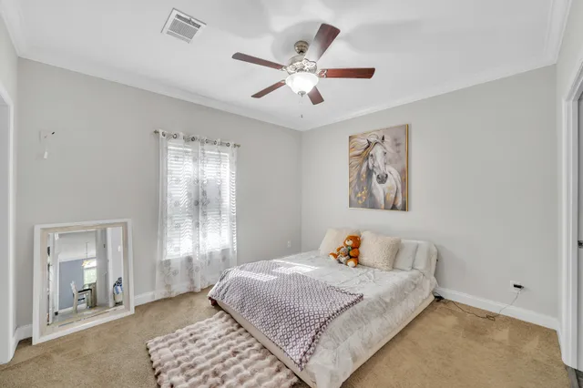 a bedroom with a large bed and a chandelier