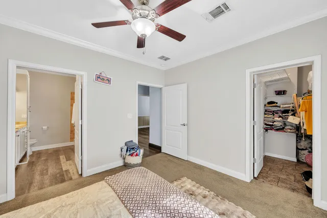a view of a livingroom with a chandelier fan and kitchen space