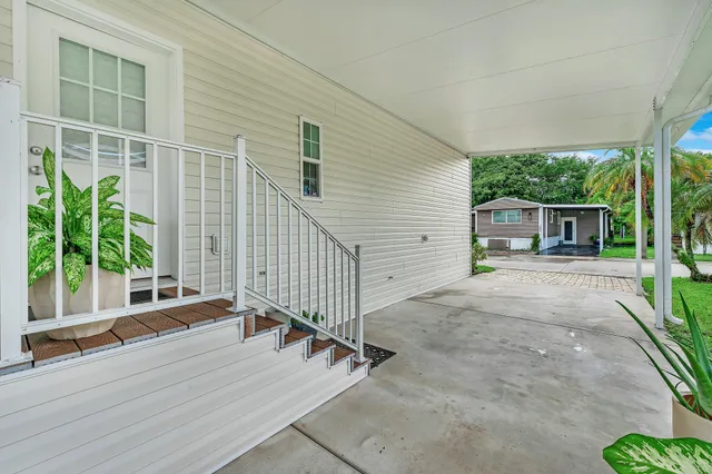 a view of a house with a yard and potted plants