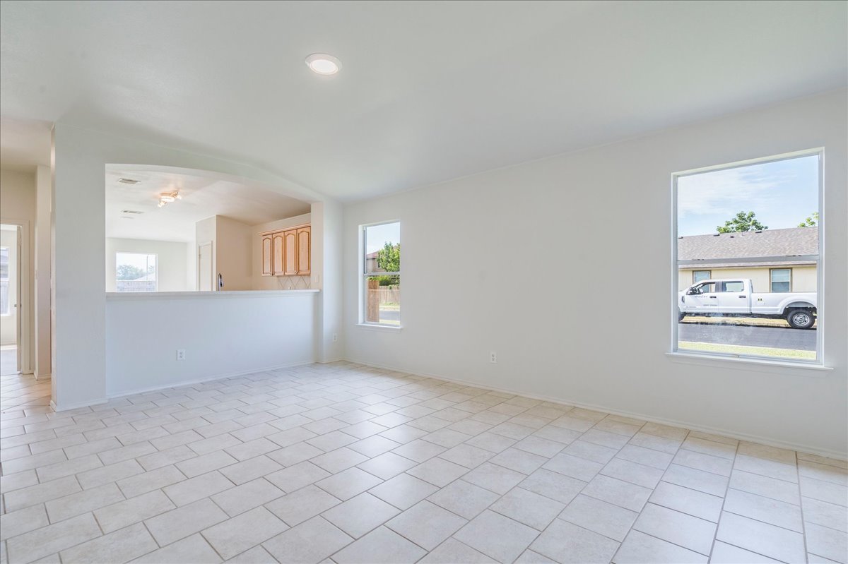 100 Easy Street Hutto, TX 78634 - Photo 11 of 36 A well-lit living area connects seamlessly to a compact kitchen through a convenient pass-through.
