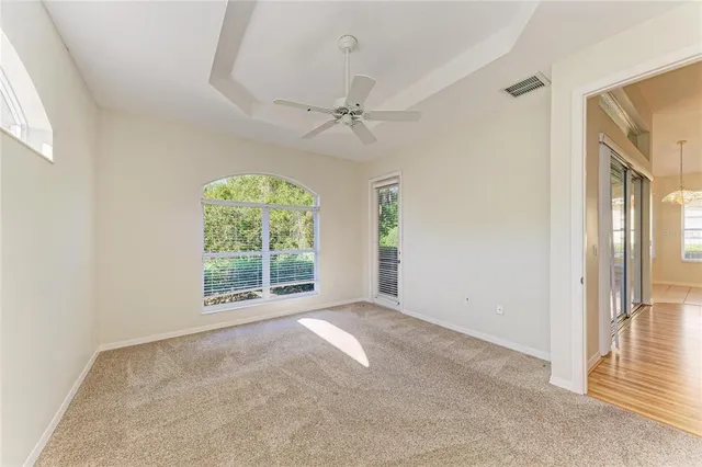 an empty room with a ceiling fan and a window