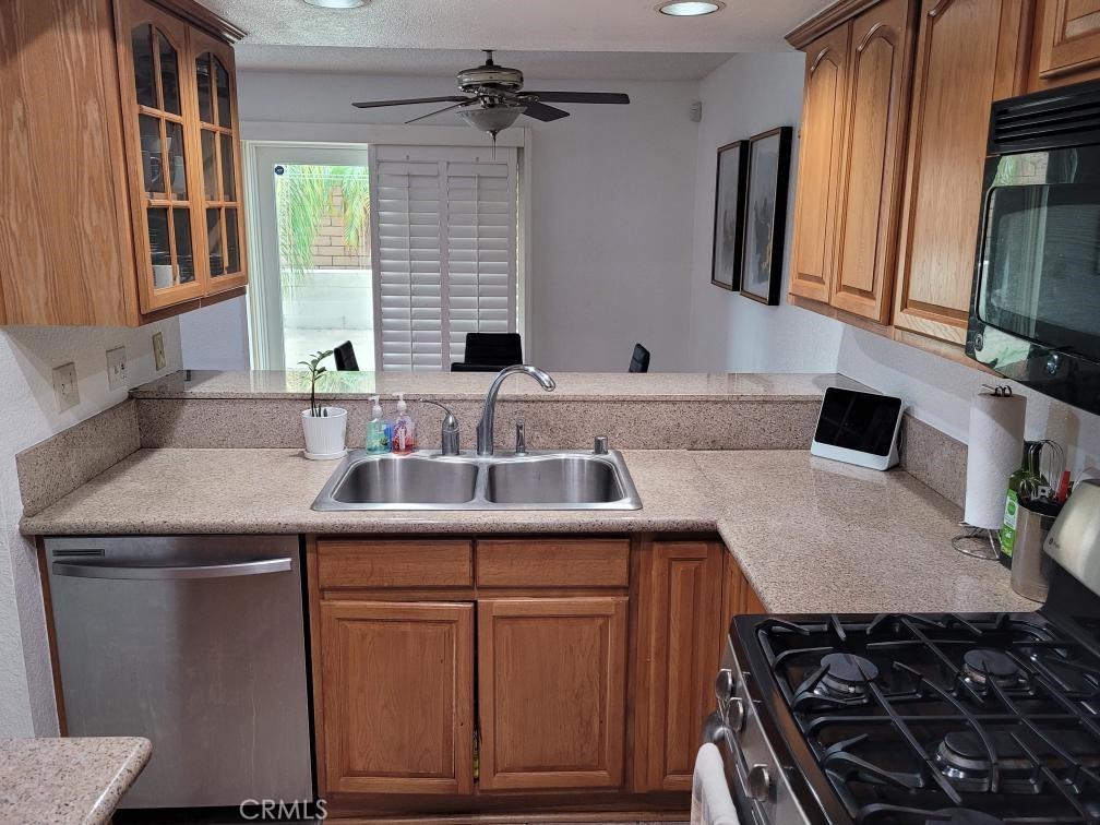 7449 Langham Place Rancho Cucamonga, CA 91730 - Photo 5 of 6 a kitchen with a sink stove and cabinets