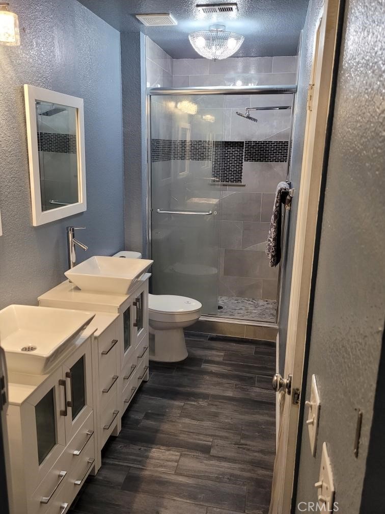 7449 Langham Place Rancho Cucamonga, CA 91730 - Photo 6 of 6 a bathroom with a granite countertop sink a toilet a mirror and shower