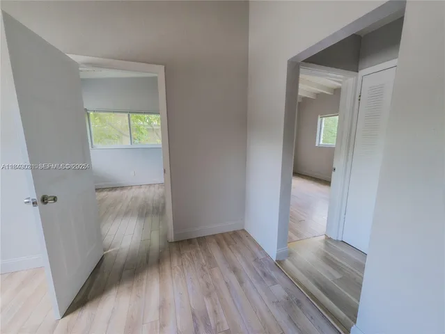 an empty room with wooden floor and a window