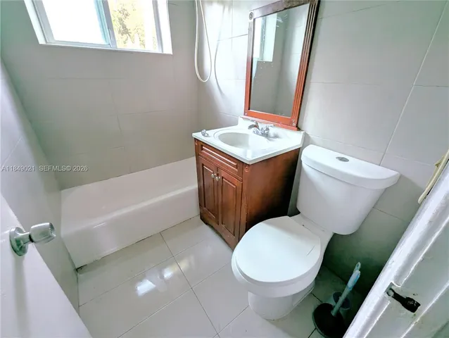 a white toilet sitting next to a bathroom sink and tub