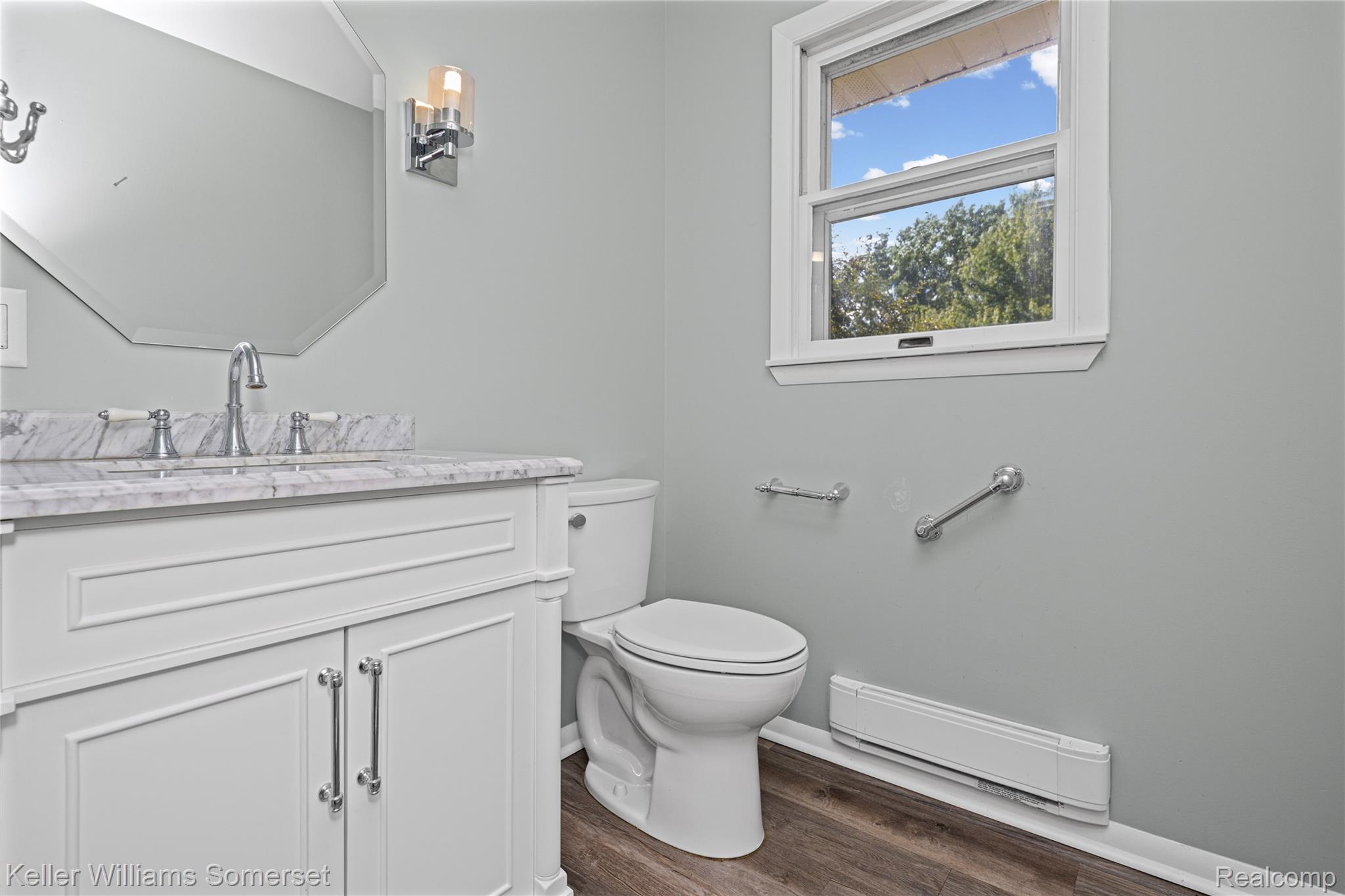 2344 Rochester Road Leonard, MI 48367 - Photo 23 of 66 Bathroom featuring a white vanity with a marble-finish countertop, chrome faucet, and an octagonal wall mirror
