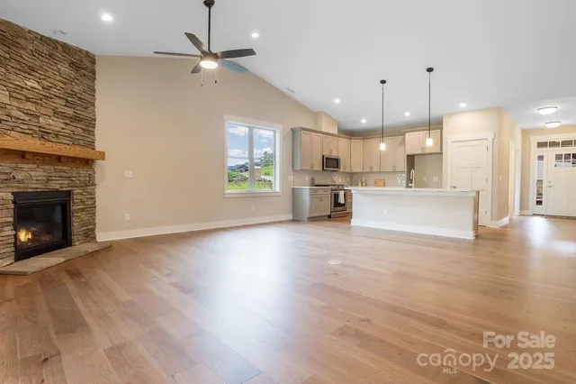 a view of an empty room with a fireplace and a window