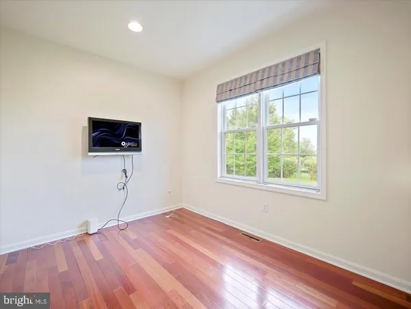 a view of a room with wooden floor and windows