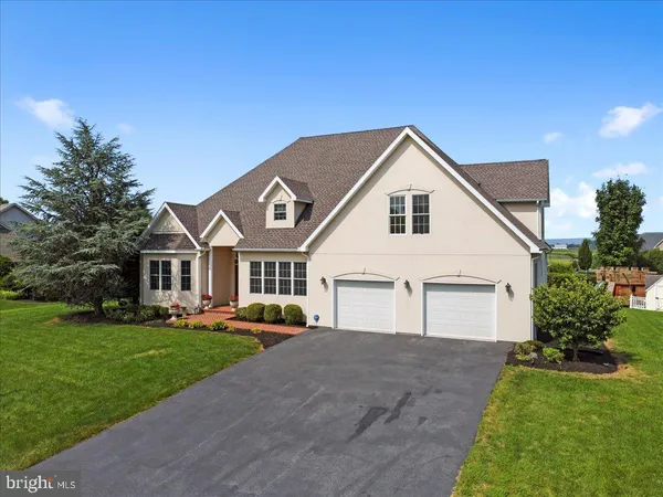 a front view of a house with a yard and trees