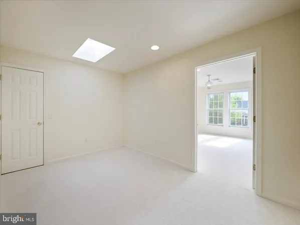 an empty room with windows and mirror