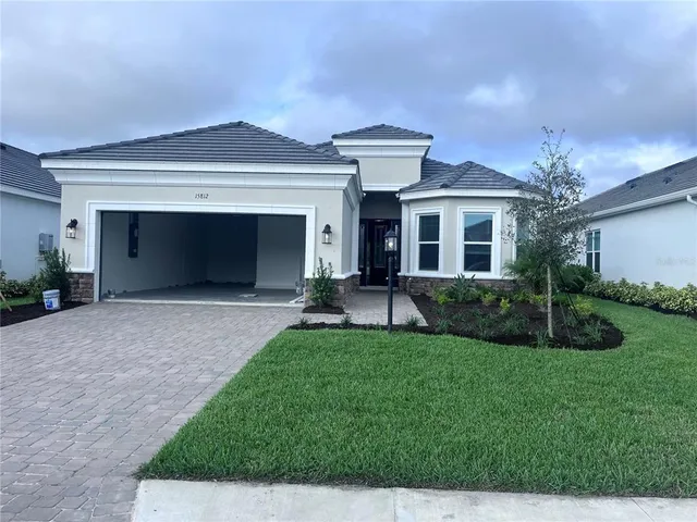 a front view of a house with a garden and yard