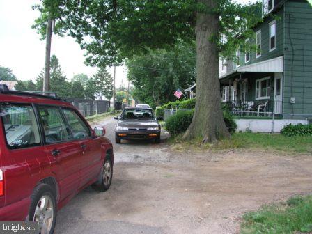 a view of a yard with a car parked in front of a house
