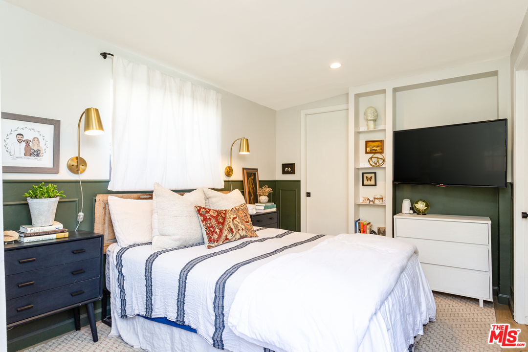 1663 South Rimpau Boulevard Los Angeles, CA 90019 - Photo 14 of 21 a bedroom with a bed and a flat screen tv