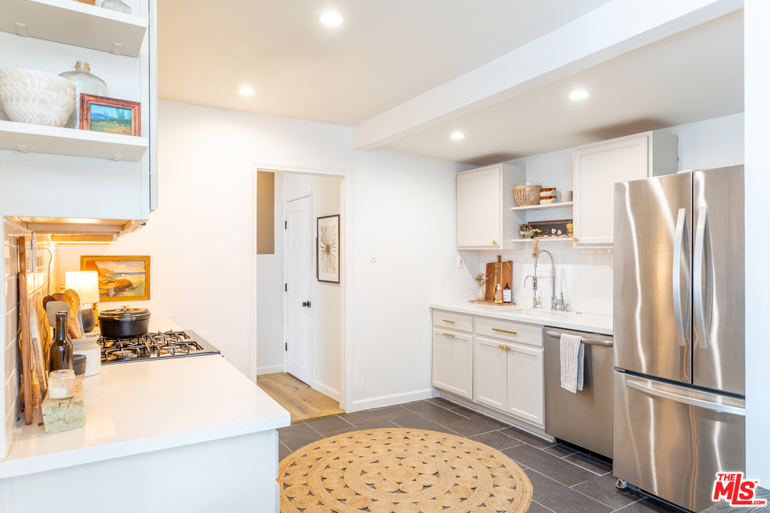 1663 South Rimpau Boulevard Los Angeles, CA 90019 - Photo 10 of 21 a kitchen with stainless steel appliances granite countertop a refrigerator and a sink