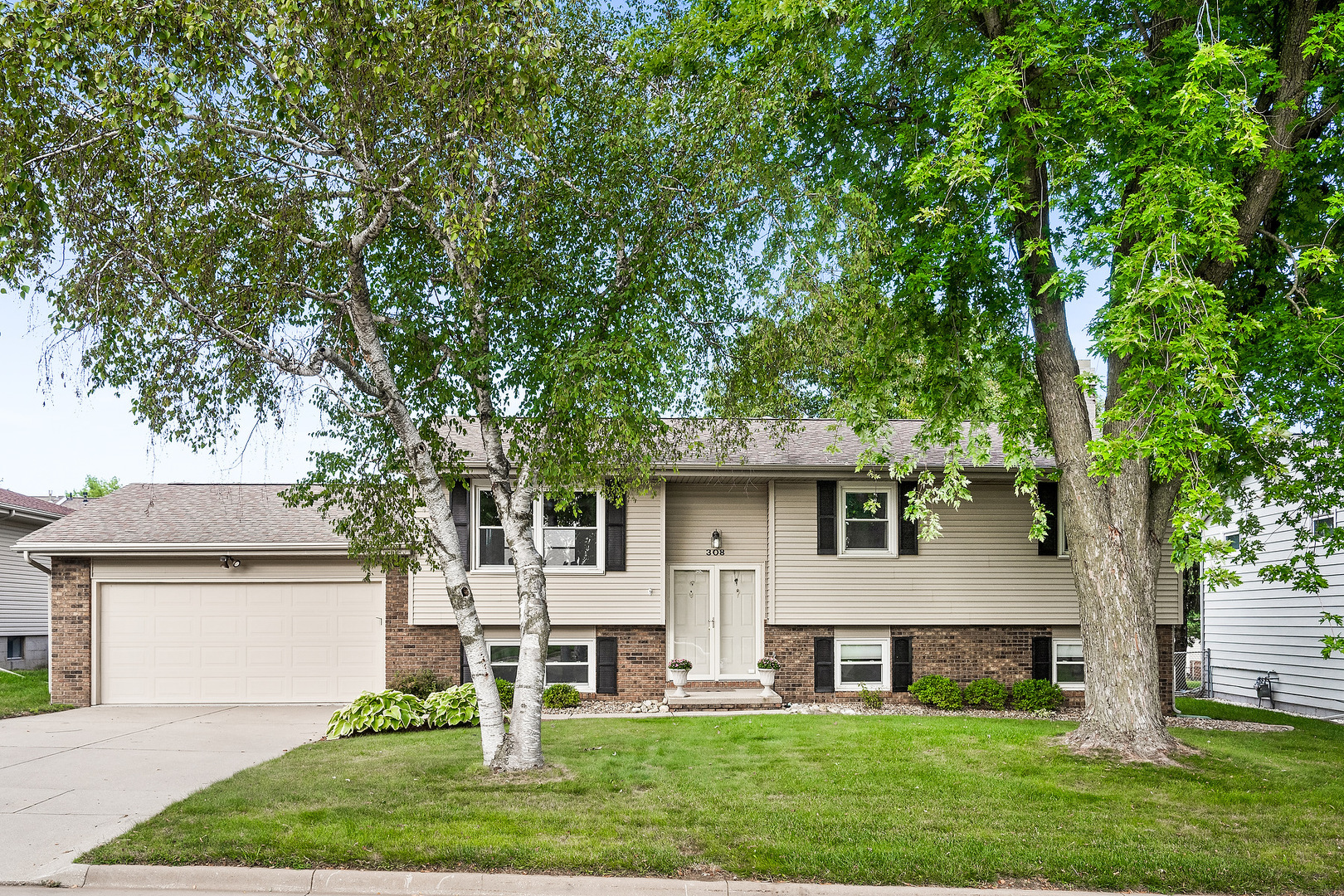 a front view of a house with a yard and trees