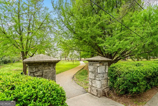a front view of a house with a garden and fountain