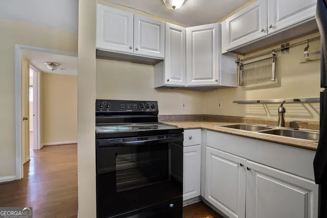 a kitchen with cabinets stainless steel appliances and wooden floor