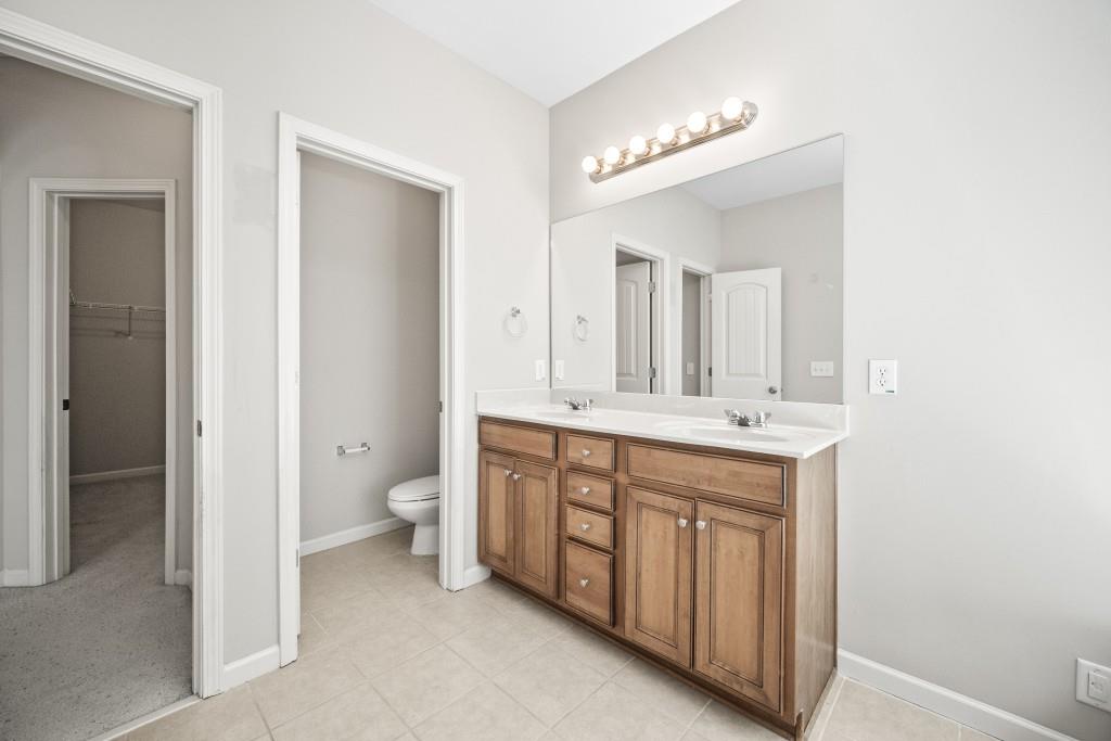 100 Trailside Way Hiram, GA 30141 - Photo 18 of 28 a spacious bathroom with a double vanity sink a toilet and a mirror
