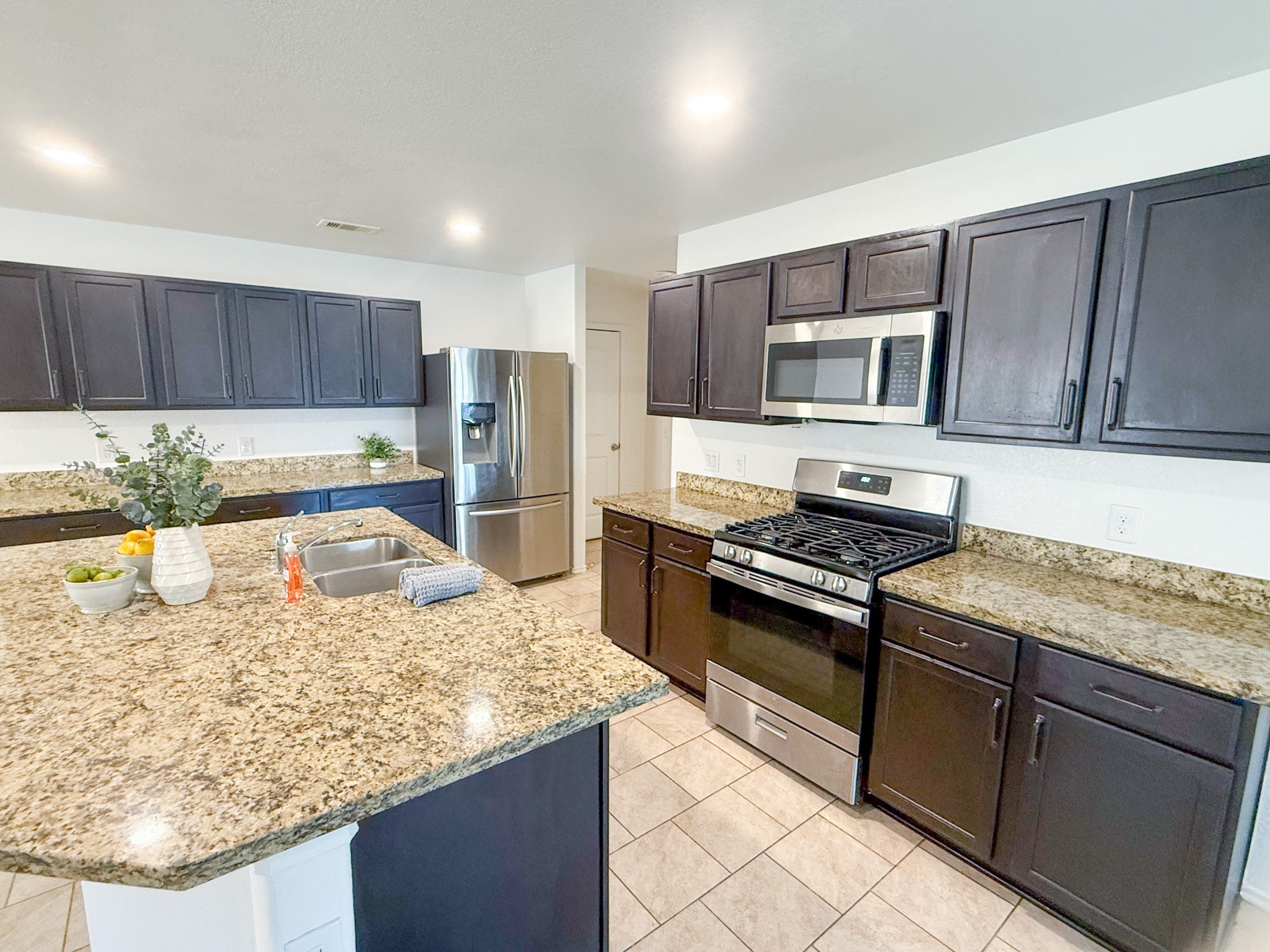 23319 Robbers Nest Drive Spring, TX 77373 - Photo 11 of 42 a kitchen with stainless steel appliances granite countertop a stove a sink and a microwave