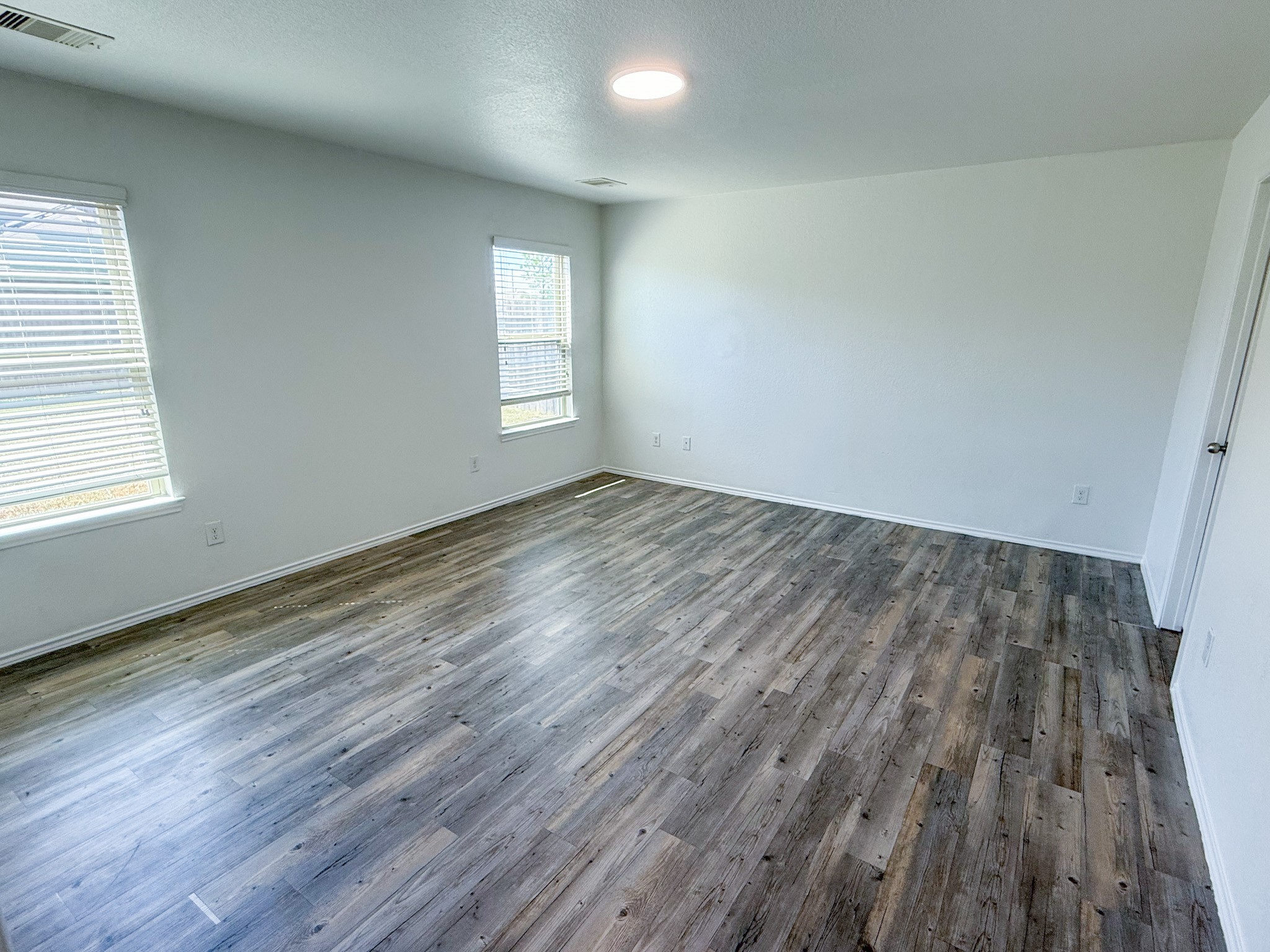 23319 Robbers Nest Drive Spring, TX 77373 - Photo 28 of 42 an empty room with wooden floor and windows