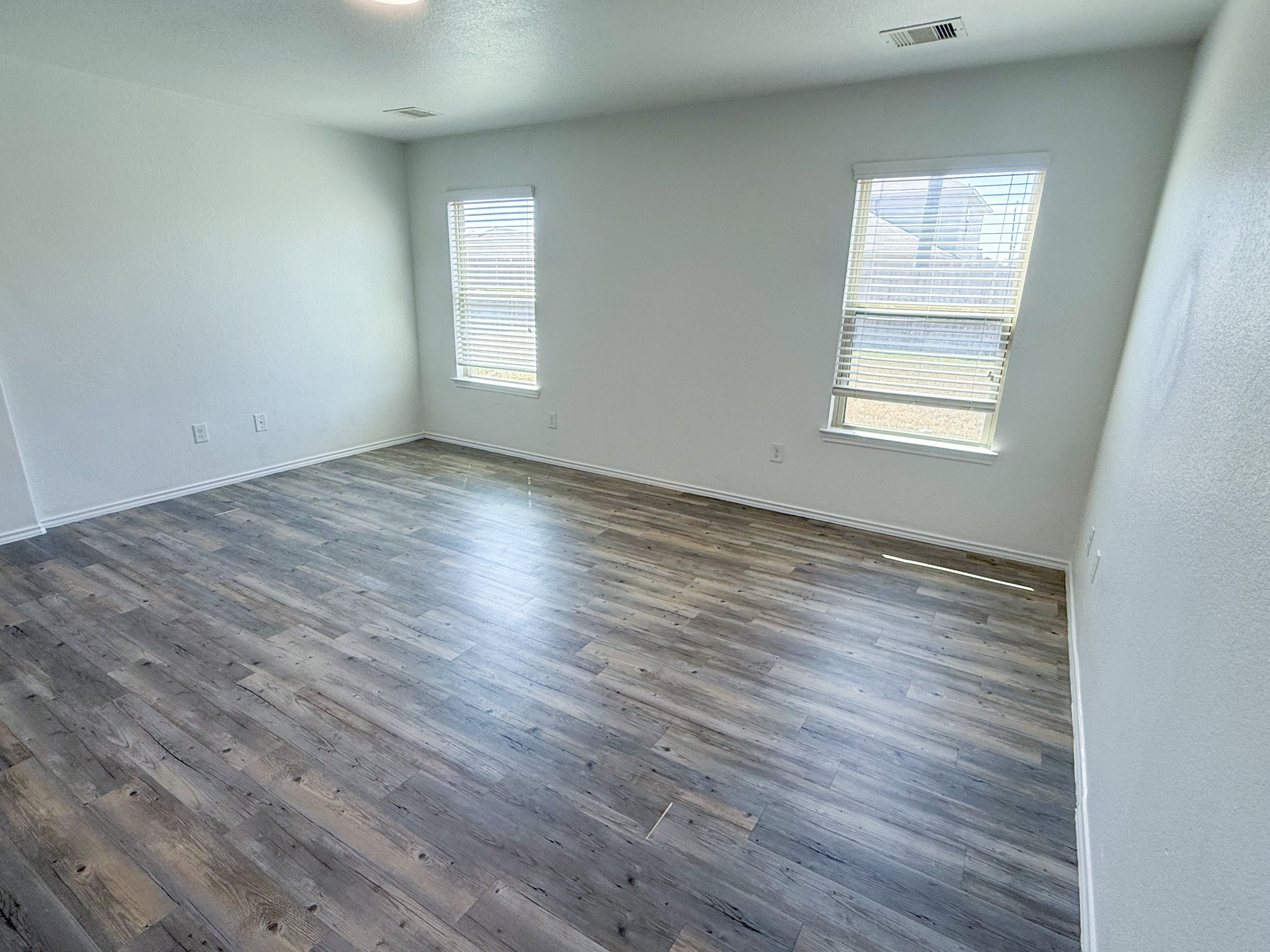 23319 Robbers Nest Drive Spring, TX 77373 - Photo 30 of 42 an empty room with wooden floor and windows