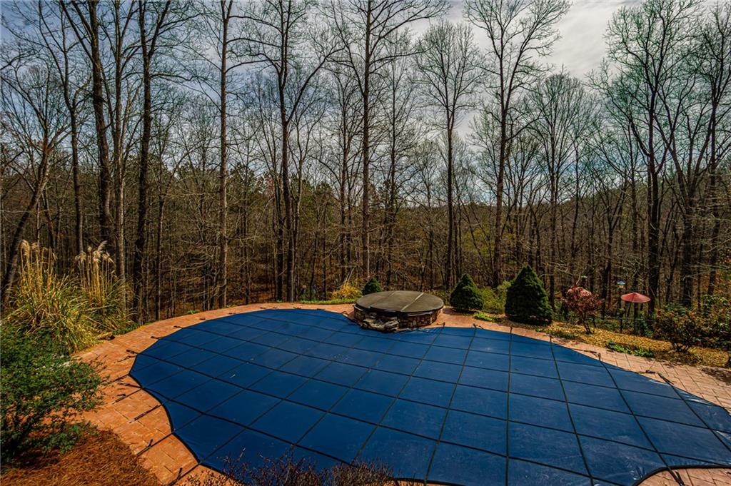 3718 Pebble Creek Point Gainesville, GA 30506 - Photo 107 of 144 a backyard of a house with table and chairs under an umbrella