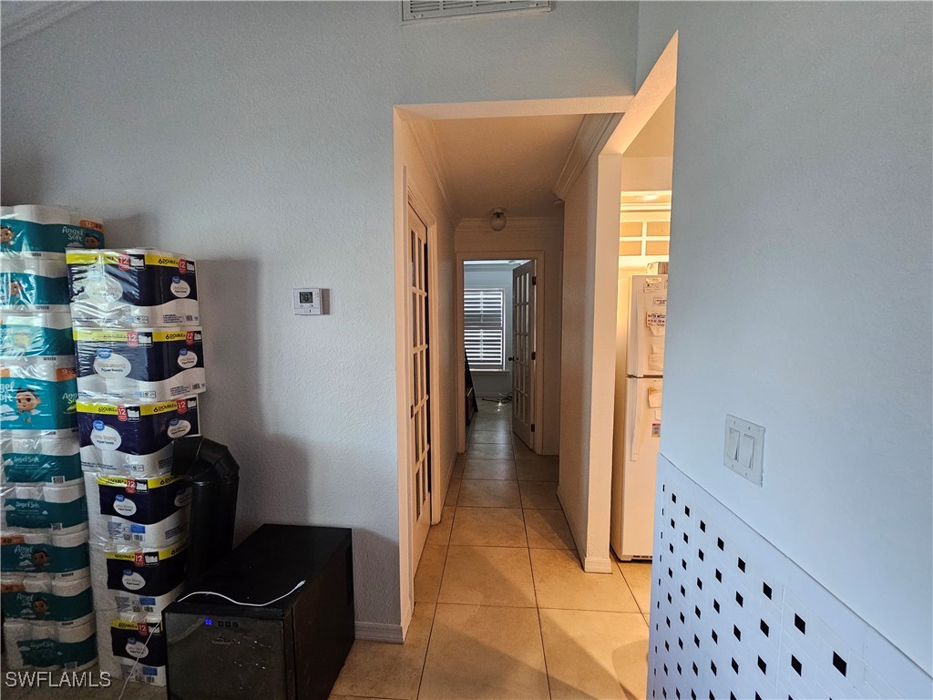 3903 1st Street Southwest Lehigh Acres, FL 33976 - Photo 6 of 25 a hallway with painting on the wall and a potted plant