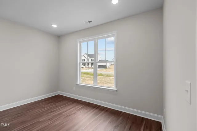 a view of an empty room with wooden floor