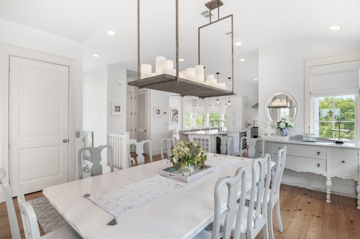 187 Cypress Drive Santa Rosa Beach, FL 32459 - Photo 17 of 58 a kitchen with stainless steel appliances kitchen island granite countertop a stove a sink a dining table and chairs with wooden floor