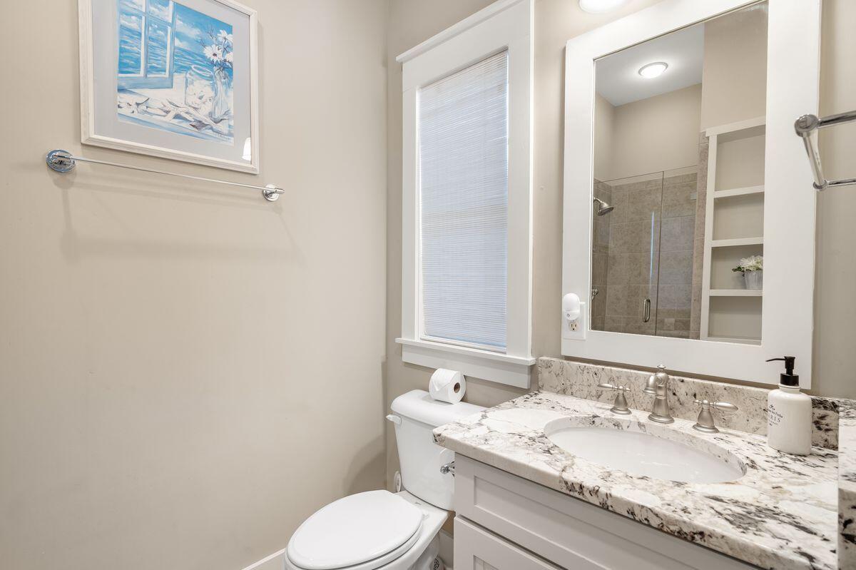 187 Cypress Drive Santa Rosa Beach, FL 32459 - Photo 34 of 58 a bathroom with a granite countertop toilet sink and mirror