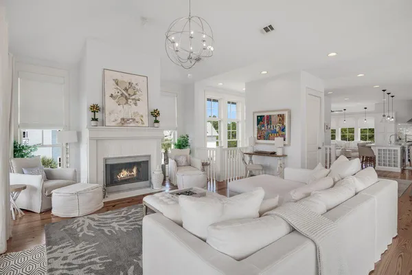 a view of a dining room and livingroom with furniture wooden floor kitchen view