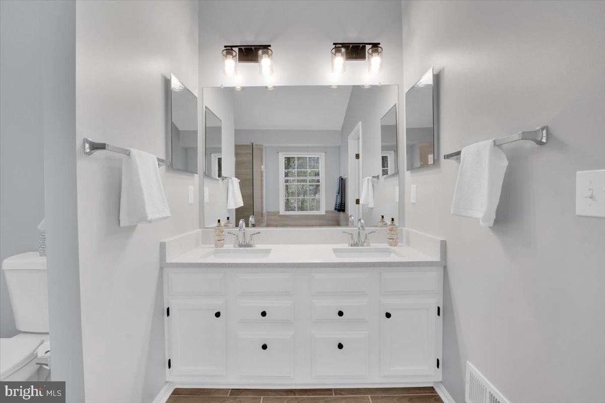 7523 Westmore Drive Springfield, VA 22150 - Photo 18 of 37 a bathroom with double vanity sink and a mirror