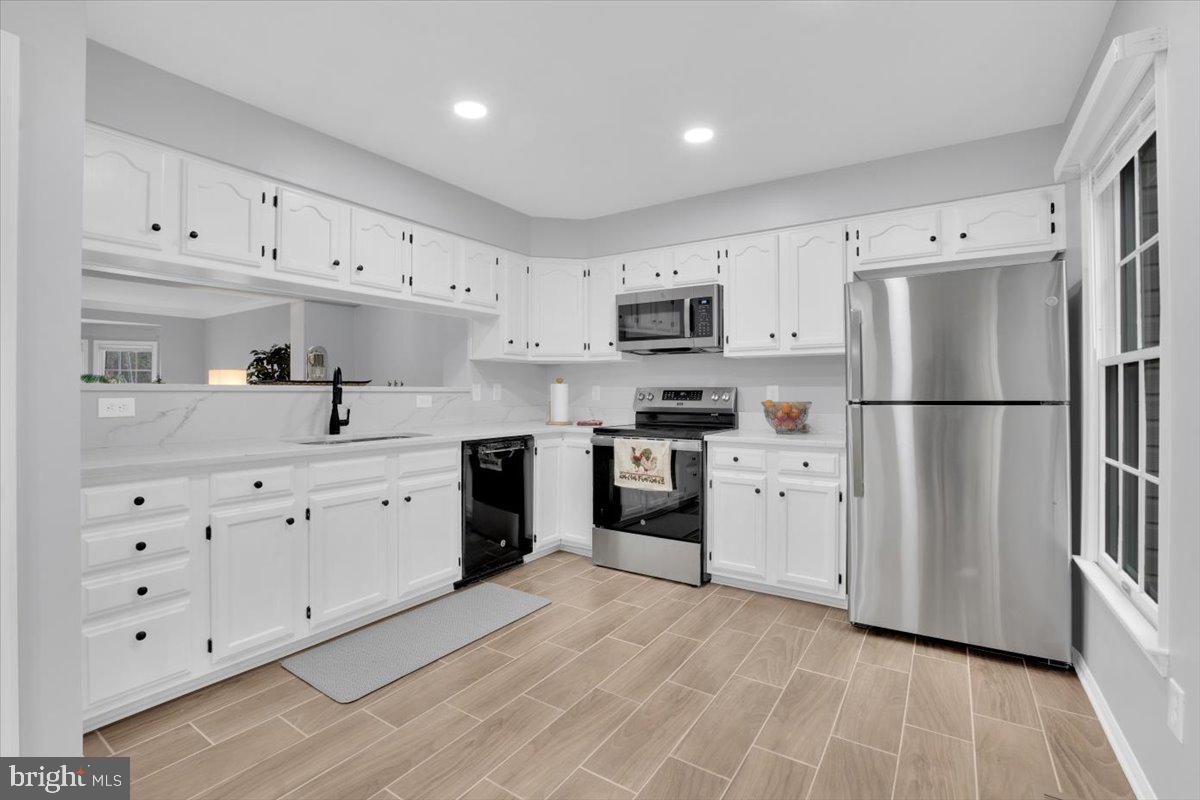 7523 Westmore Drive Springfield, VA 22150 - Photo 9 of 37 a kitchen with white cabinets white stainless steel appliances and sink
