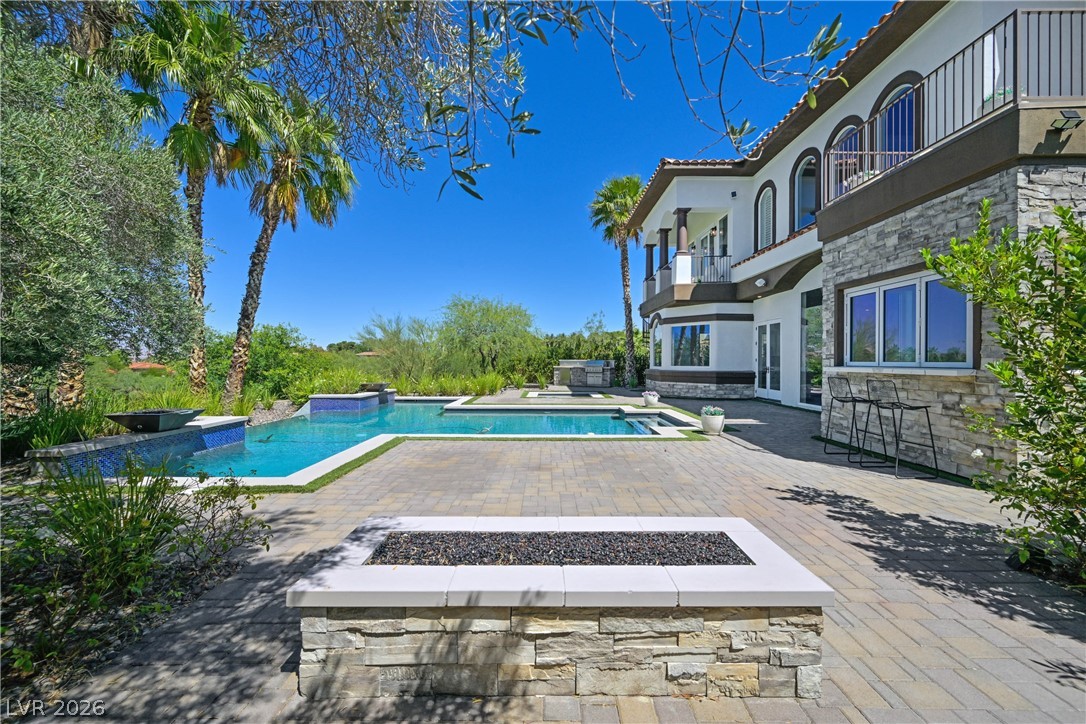 6 Rue Du Ville Henderson, NV 89011 - Photo 76 of 99 This magnificent outdoor living space features a sparkling pool and a charming fire pit, perfect for gatherings.