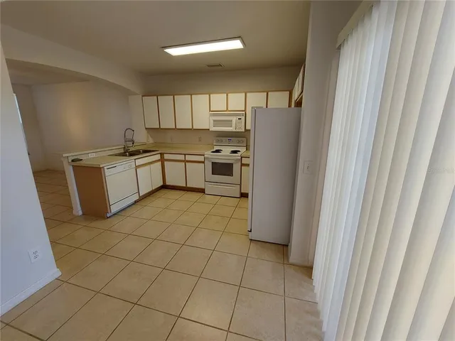 a kitchen with a refrigerator and white cabinets