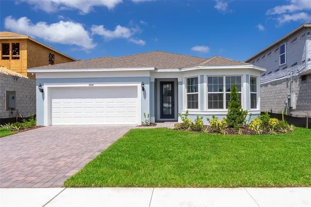 a front view of a house with a garden and plants