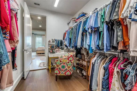 a view of walk in closet with clothes and shoes