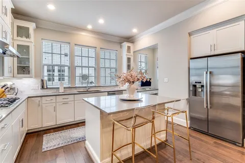 a kitchen with stainless steel appliances granite countertop a sink and a refrigerator