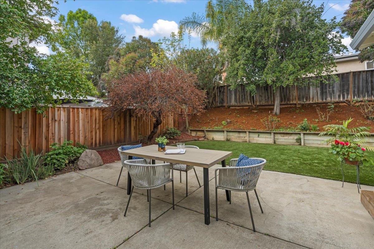 6535 Kings Place Gilroy, CA 95020 - Photo 22 of 25 a view of a backyard with table and chairs potted plants and wooden fence