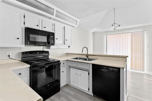 a kitchen with cabinets stainless steel appliances a sink and a window