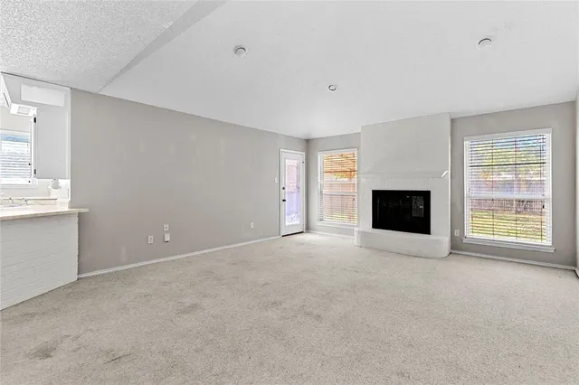 a view of an empty room with a fireplace and a window